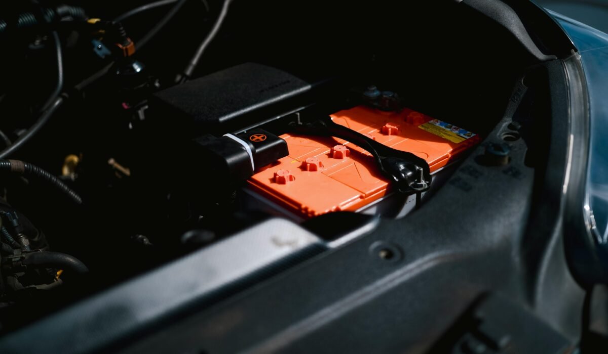 Detailed view of an electric car battery inside a vehicle's engine compartment, highlighting sustainable technology. — Photo by Ayyeee Ayyeee on Pexels