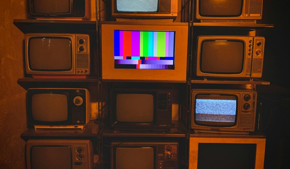 A collection of vintage televisions featuring static and color test patterns on the screens. — Photo by Marshal Yung on Pexels