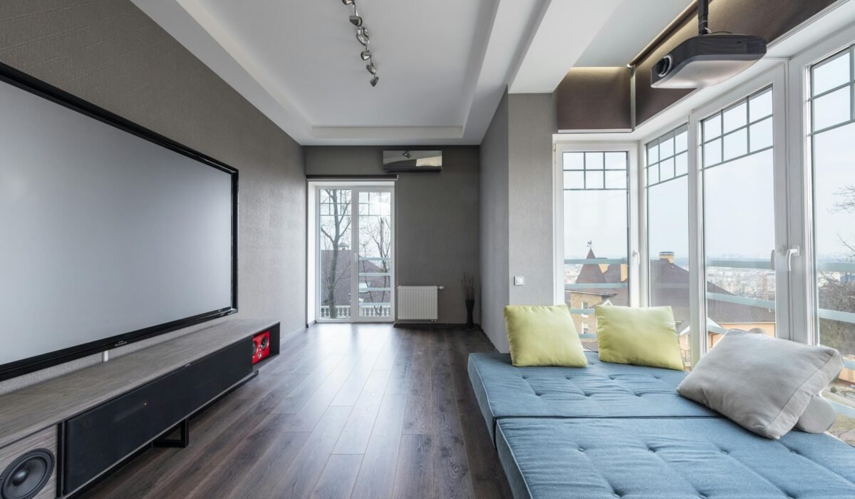 Comfortable settee with colorful cushions placed near big windows against contemporary television set in spacious room of modern stylish apartment — Photo by Max Vakhtbovych on Pexels