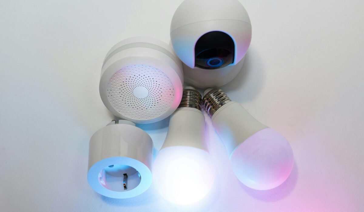 A collection of smart home devices including light bulbs, a security camera, and a smart hub. — Photo by Jakub Zerdzicki on Pexels