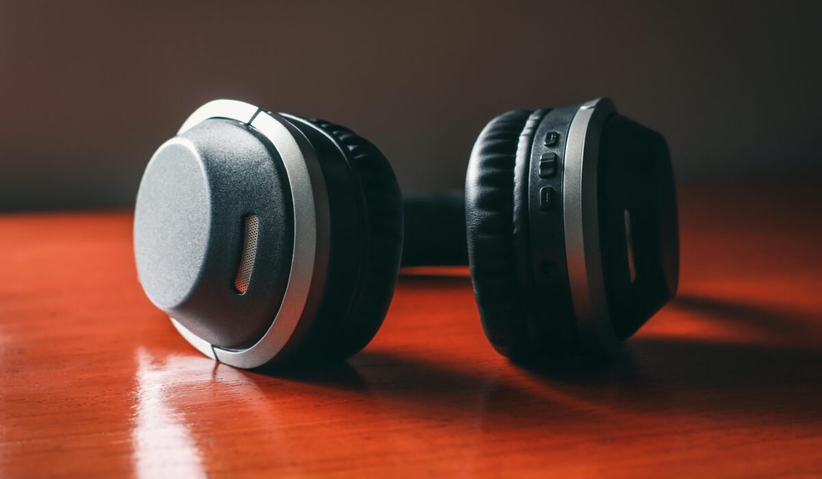 Close-up of wireless headphones on a wooden table, emphasizing design and technology. — Photo by Harvey Tan Villarino on Pexels
